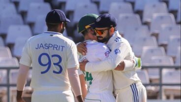 Virat Kohli hugs Dean Elgar as Jasprit Bumrah looks on.